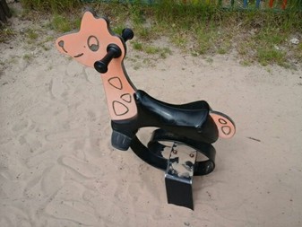 Giraffe rocker situated on sand