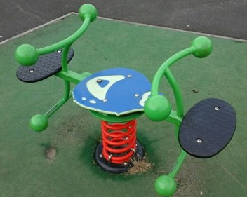 Tractor spring rocker situated on grass matting