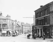 Graphic - Brookbottom, George Hotel on the corner and Brooks florist across the road, Car and delivery van parked on road, Butchers arms and 3 storey cottages on Stockport Road